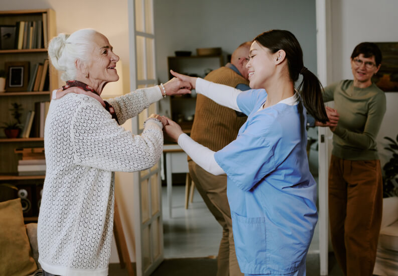 Female Nurse Dancing With Elderly Residents at Assisted Living Facility Female Nurse Dancing With Elderly Residents at Assisted Living Facility