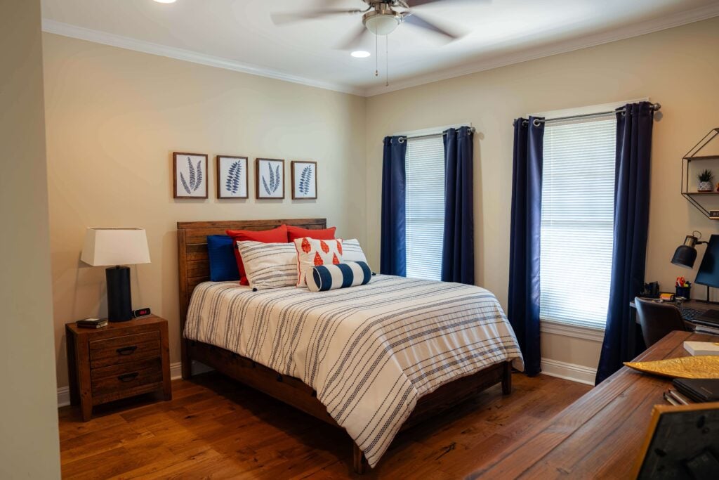 Bedroom With Striped Bedding and Desk in Independent Living Cottages