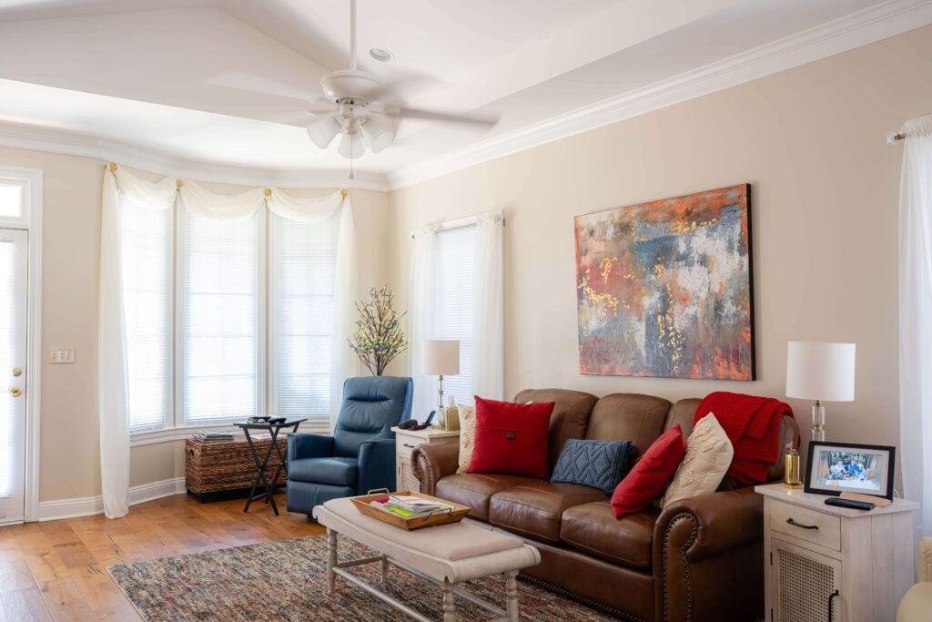 Bright Living Room With Leather Sofa in Independent Living Cottages