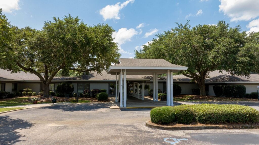 Welcoming Covered Entrance With Rocking Chairs at Assisted Living Facility