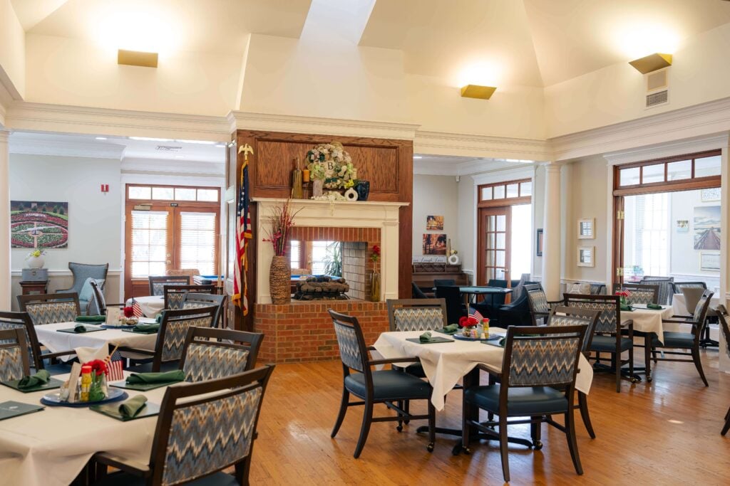 Main Dining Room With Double-Sided Brick Fireplace at Assisted Living Facility